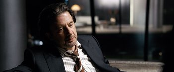 Movie still from “The International” (2009), directed by Tom Tykwer – A person wearing a suit and tie; Close Up shot, Over the shoulder angle
