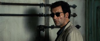 Movie still from “The International” (2009), directed by Tom Tykwer – A person wearing a jacket and sunglasses; Close Up shot, Low angle