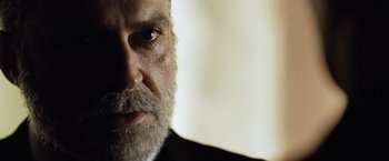 Movie still from “The International” (2009), directed by Tom Tykwer – A person with a beard; Close Up shot, Over the shoulder angle