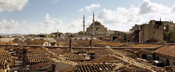 Movie still from “The International” (2009), directed by Tom Tykwer – A view of a city with a mosque in the background; Extreme Wide shot, Low angle