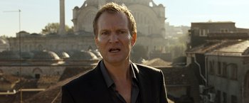 Movie still from “The International” (2009), directed by Tom Tykwer – A person wearing a suit; Close Up shot, Low angle