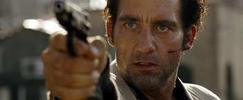 Movie still from “The International” (2009), directed by Tom Tykwer – A person holding a gun; Close Up shot, Low angle