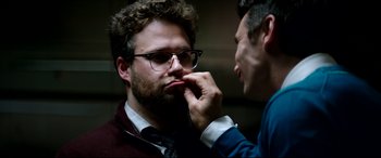 Movie still from “The Interview” (2014), directed by Evan Goldberg – A man in a suit and tie touching his face; Close Up shot, Over the shoulder angle