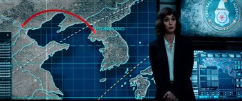 Movie still from “The Interview” (2014), directed by Evan Goldberg – A woman standing in front of a large map of north and south korea; Medium shot, High angle