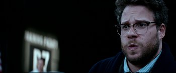 Movie still from “The Interview” (2014), directed by Evan Goldberg – A person wearing a suit and glasses; Close Up shot, Over the shoulder angle