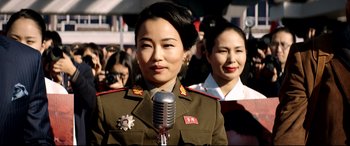 Movie still from “The Interview” (2014), directed by Evan Goldberg – A woman in a military uniform is holding a microphone; Close Up shot, Over the shoulder angle