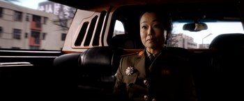 Movie still from “The Interview” (2014), directed by Evan Goldberg – A woman in a uniform sitting in the back seat of a car; Close Up shot, Over the shoulder angle