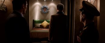 Movie still from “The Interview” (2014), directed by Evan Goldberg – A man standing in front of a bed in a room; Medium shot, Over the shoulder angle