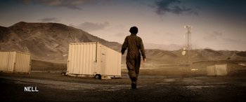 Movie still from “The Interview” (2014), directed by Evan Goldberg – A person walking in front of a white container; Extreme Wide shot, Low angle