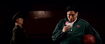 Movie still from “The Interview” (2014), directed by Evan Goldberg – A man holding a drink in his hand; Medium shot, Over the shoulder angle