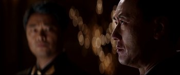 Movie still from “The Interview” (2014), directed by Evan Goldberg – A person's face with lights in the background; Close Up shot, Over the shoulder angle