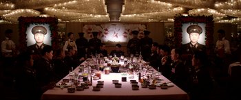Movie still from “The Interview” (2014), directed by Evan Goldberg – A group of people sitting around a table with food on it; Wide shot, High angle