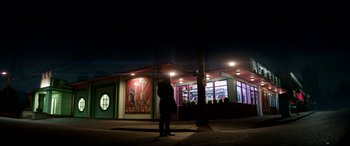 Movie still from “The Interview” (2014), directed by Evan Goldberg – A person standing in front of a building at night; Extreme Wide shot, Low angle
