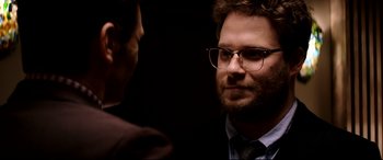 Movie still from “The Interview” (2014), directed by Evan Goldberg – A man in a suit and tie talking to another man in a suit and tie; Close Up shot, Over the shoulder angle