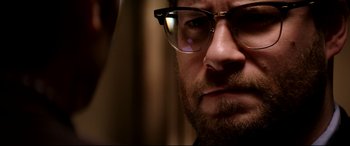 Movie still from “The Interview” (2014), directed by Evan Goldberg – A person wearing glasses; Close Up shot, Over the shoulder angle