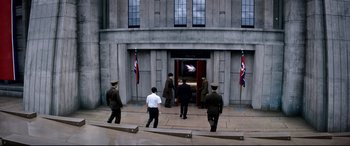 Movie still from “The Interview” (2014), directed by Evan Goldberg – A group of men standing in front of a building; Wide shot, High angle