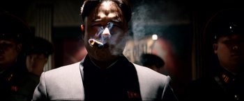 Movie still from “The Interview” (2014), directed by Evan Goldberg – A man smoking a cigarette while wearing a suit; Close Up shot, Low angle