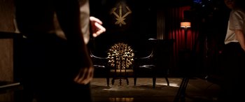 Movie still from “The Interview” (2014), directed by Evan Goldberg – Two chairs in a room with a clock in the background; Wide shot, High angle