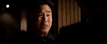 Movie still from “The Interview” (2014), directed by Evan Goldberg – A person wearing a suit and tie; Close Up shot, Low angle