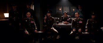 Movie still from “The Interview” (2014), directed by Evan Goldberg – A group of men sitting at a table in a room; Medium shot, Low angle