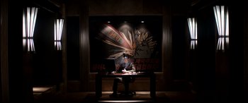 Movie still from “The Interview” (2014), directed by Evan Goldberg – A man sitting at a table with a laptop in front of him; Wide shot, Low angle