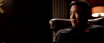 Movie still from “The Interview” (2014), directed by Evan Goldberg – A man sitting in a chair with his head turned to the side; Close Up shot, Over the shoulder angle