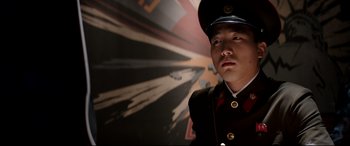 Movie still from “The Interview” (2014), directed by Evan Goldberg – A man in a uniform is standing in front of a wall; Close Up shot, Low angle