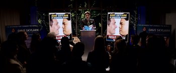 Movie still from “The Interview” (2014), directed by Evan Goldberg – A man reading a book at a podium; Medium shot, Over the shoulder angle