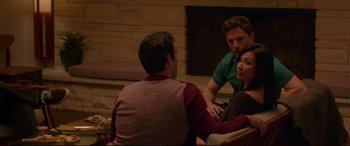 Movie still from “The Invitation” (2015), directed by Karyn Kusama – A group of people sitting in a living room talking; Medium shot, Over the shoulder angle