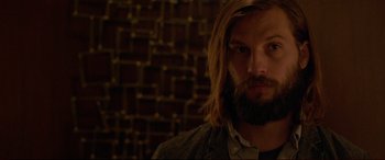 Movie still from “The Invitation” (2015), directed by Karyn Kusama – A person with long hair and a beard; Close Up shot, Over the shoulder angle