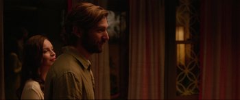 Movie still from “The Invitation” (2015), directed by Karyn Kusama – A man with long hair and a goatee looking to his left; Close Up shot, Over the shoulder angle