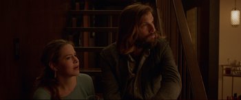 Movie still from “The Invitation” (2015), directed by Karyn Kusama – A man and a woman sitting next to each other in a room; Medium shot, Over the shoulder angle