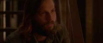 Movie still from “The Invitation” (2015), directed by Karyn Kusama – A man with long hair and a long beard; Close Up shot, Over the shoulder angle