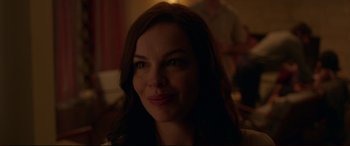 Movie still from “The Invitation” (2015), directed by Karyn Kusama – A person smiling for the camera; Close Up shot, Over the shoulder angle