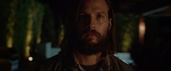 Movie still from “The Invitation” (2015), directed by Karyn Kusama – A man with long hair and a goatee stares into the camera; Close Up shot, Low angle