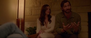 Movie still from “The Invitation” (2015), directed by Karyn Kusama – A woman sitting next to a man on a couch; Medium shot, Over the shoulder angle