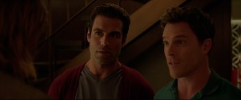 Movie still from “The Invitation” (2015), directed by Karyn Kusama – A man standing next to another man in a room; Close Up shot, Over the shoulder angle