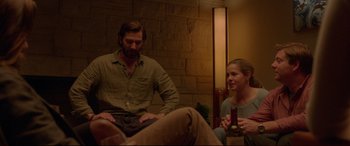 Movie still from “The Invitation” (2015), directed by Karyn Kusama – A man and a woman sitting on a couch; Medium shot, Over the shoulder angle