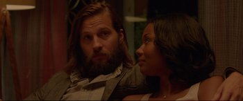 Movie still from “The Invitation” (2015), directed by Karyn Kusama – A man and a woman sitting next to each other; Close Up shot, Over the shoulder angle