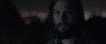 Movie still from “The Invitation” (2015), directed by Karyn Kusama – A man with long hair and a goatee stares at the camera; Close Up shot, Low angle