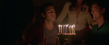 Movie still from “The Invitation” (2015), directed by Karyn Kusama – A man and a woman blowing out candles on a birthday cake; Close Up shot, Over the shoulder angle