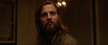 Movie still from “The Invitation” (2015), directed by Karyn Kusama – A man with long hair and a long beard; Close Up shot, Over the shoulder angle