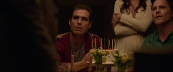 Movie still from “The Invitation” (2015), directed by Karyn Kusama – A man sitting in front of a cake with candles on it; Close Up shot, Over the shoulder angle