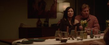 Movie still from “The Invitation” (2015), directed by Karyn Kusama – A woman sitting at a dinner table with wine glasses; Medium shot, Over the shoulder angle
