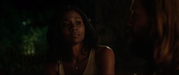 Movie still from “The Invitation” (2015), directed by Karyn Kusama – A woman with long black hair is standing in the dark; Close Up shot, Over the shoulder angle