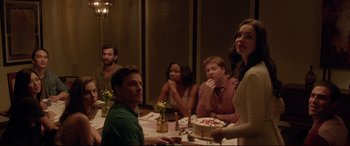 Movie still from “The Invitation” (2015), directed by Karyn Kusama – A group of people sitting at a table with a cake; Medium shot, Over the shoulder angle