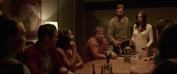 Movie still from “The Invitation” (2015), directed by Karyn Kusama – A group of people sitting around a table; Medium shot, Over the shoulder angle