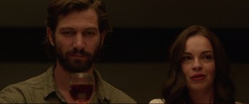 Movie still from “The Invitation” (2015), directed by Karyn Kusama – A person holding a glass of wine; Close Up shot, Over the shoulder angle