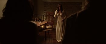 Movie still from “The Invitation” (2015), directed by Karyn Kusama – A woman in a white dress standing in front of a table; Wide shot, Over the shoulder angle