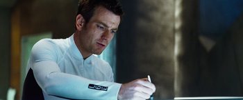 Movie still from “The Island” (2005), directed by Michael Bay – A man writing on a piece of paper with a marker; Close Up shot, Low angle